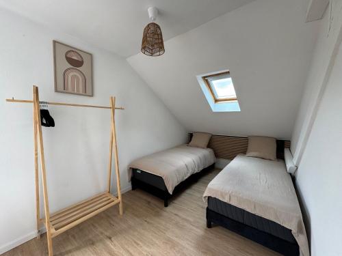 a attic bedroom with two beds and a window at Au pays des bretzels in Horbourg
