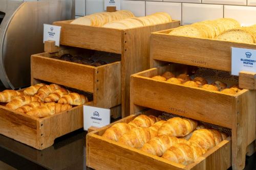 a bakery with many different types of bread in wooden baskets at Holiday Inn Express London - Epsom Downs by IHG in Epsom