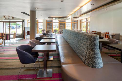 a row of tables and chairs in a restaurant at Holiday Inn Express London - Epsom Downs by IHG in Epsom