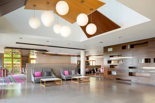 a lobby with couches and tables in a building at Holiday Inn Express London - Epsom Downs by IHG in Epsom