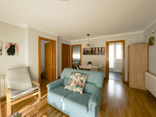 ein Wohnzimmer mit einem blauen Sofa und einem Sessel in der Unterkunft Espectacular Ático de 2 dormitorios con garaje y terraza privada de 30 m2 in Albacete