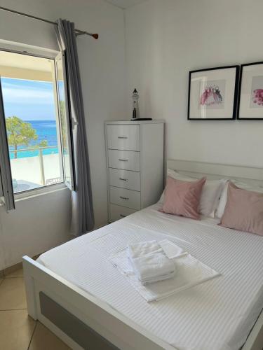 a bedroom with a bed with a view of the ocean at Spile Rooms Lukas in Himare