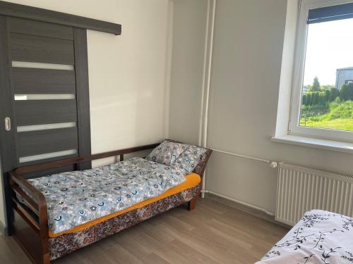 a bed in a room with a window and a couch at New place in Petřvald in Petřvald