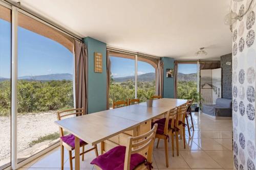 - une salle à manger avec une table, des chaises et de grandes fenêtres dans l'établissement Chambre familiale XL, à Rigarda