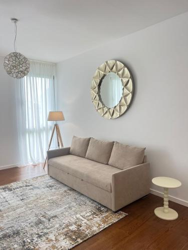 a living room with a couch and a mirror at City Center House - Azure Waters in Ribeira Grande