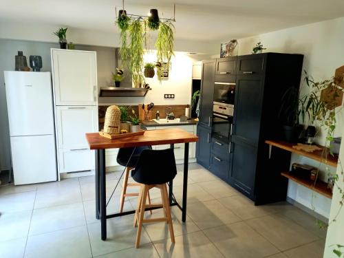 a kitchen with black cabinets and a wooden table at Gîte de charme Abelia avec extérieur au calme in Lavaur