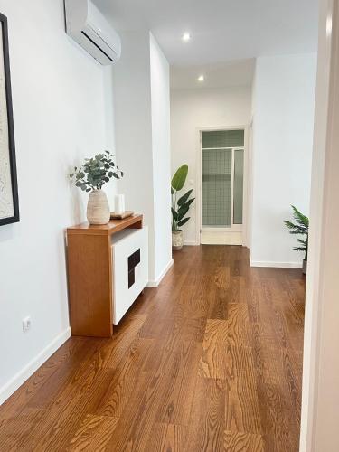 an empty living room with wooden floors and white walls at City Center House - Azure Waters in Ribeira Grande