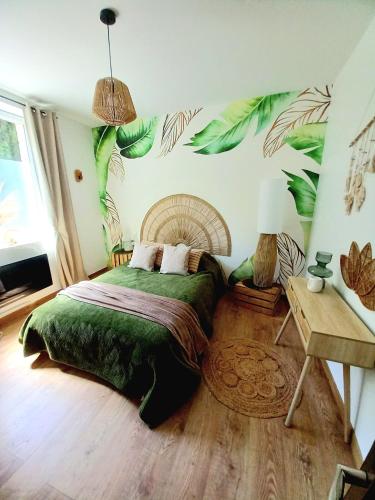 - une chambre avec un lit orné de feuilles peintes sur le mur dans l'établissement Gîte Abelia avec extérieur, à Lavaur