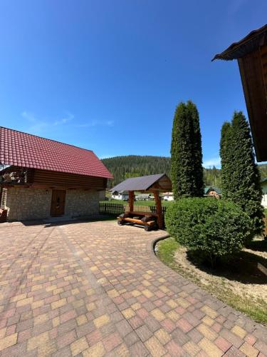 a brick driveway in front of a building with a pavilion at Садиба "Джерело" in Yaremche