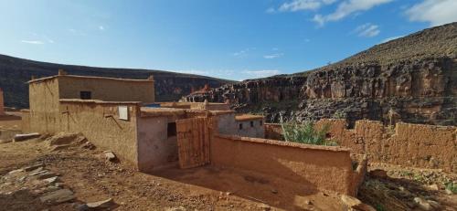 a group of buildings in the desert with a mountain at Gîte d'étape handour in Hamdour