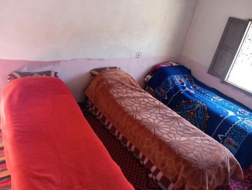 two beds in a small room with a window at Gîte d'étape handour in Hamdour