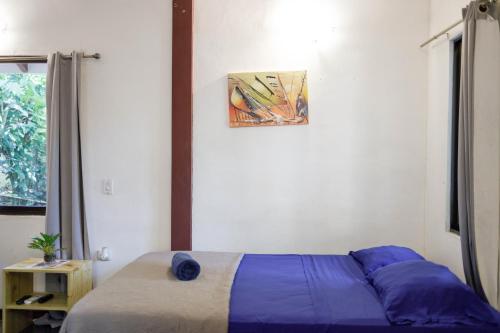 a bedroom with a bed and a picture on the wall at Bambutel Cocles in Puerto Viejo