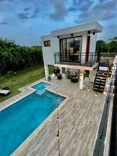 a house with a deck and a swimming pool at Elegant, Modern style Villa in Playa Nueva Romana2 in Boca del Soco
