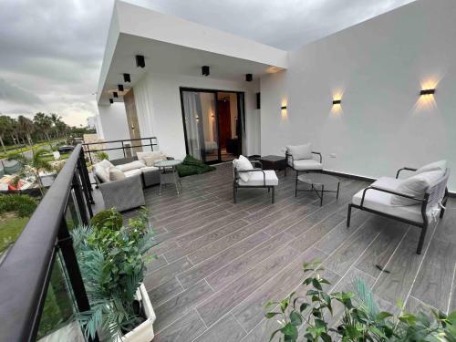 a patio with couches and chairs on a balcony at Elegant, Modern style Villa in Playa Nueva Romana2 in Boca del Soco