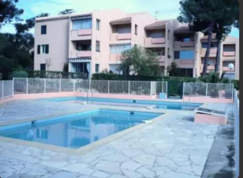 - une piscine en face d'un immeuble dans l'établissement Appartement Bandol dans résidence privée avec piscine, à Bandol