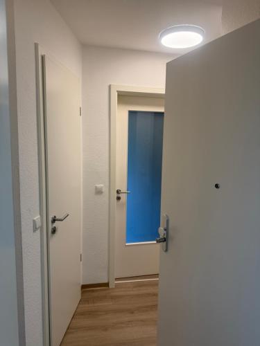 an empty room with a door with a blue window at Über den Dächern von Werne - Balkon, WLAN, TV und Küche - Möller in Werne an der Lippe