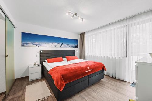 a bedroom with a large bed with red pillows at Herzblut Wohlfühl Appartements in Oetz