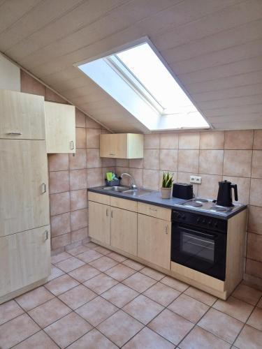a kitchen with a stove and a skylight at Auszeit und Idylle auf dem Pferdehof in Kirchberg an der Murr