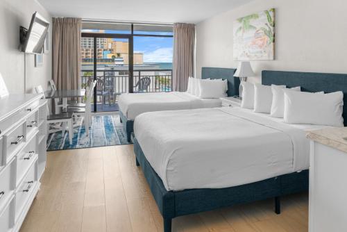 a hotel room with two beds and a balcony at Modern & Updated Oceanview Studio! Sleeps 4! Landmark 523 in Myrtle Beach