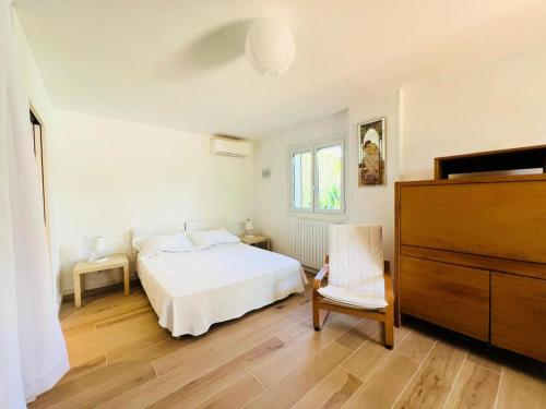 une chambre avec un lit blanc et une chaise dans l'établissement Villa Farniente - Villa idéale pour les familles MAE-4114, à La Grande Motte
