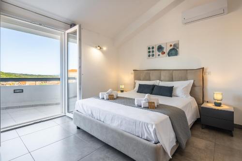 a bedroom with a large bed and a large window at Casa Giulia in Gonnesa