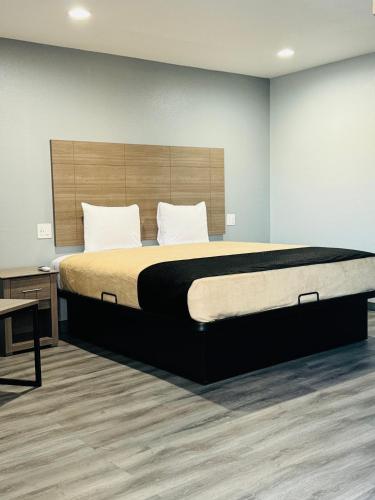 a bedroom with a large bed with a wooden headboard at EXPRESS INN & Suites in El Campo