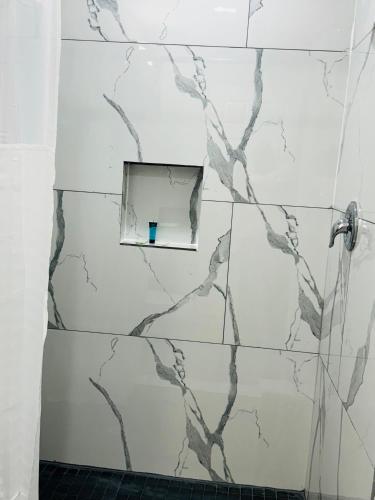 a white tiled bathroom with a window in the wall at EXPRESS INN & Suites in El Campo