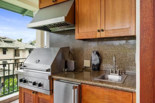una cocina con fregadero y estufa en Big Island Kolea 11C by Coldwell Banker Island Vacations, en Waikoloa
