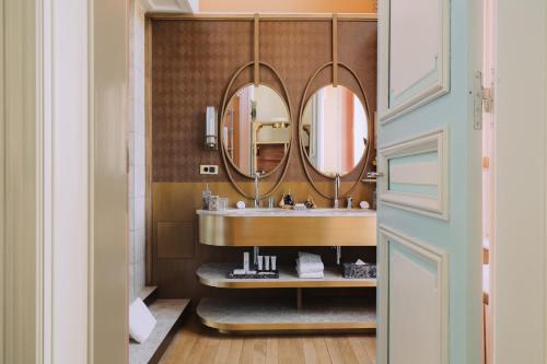 a bathroom with a sink and two mirrors at Villa Pétrusse in Luxembourg