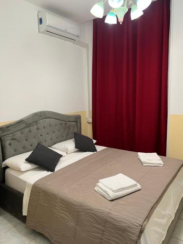 SALENTINI APPARTAMENTo في روما: غرفة نوم بسرير وستارة حمراء