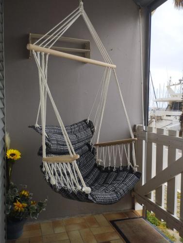 - un hamac suspendu sur le balcon d'une maison dans l'établissement Apt de charme 4 pers, vue port, location idéale, à Gruissan