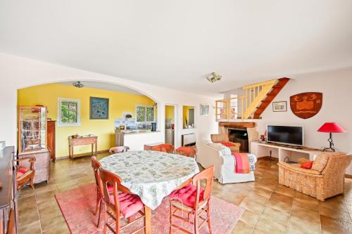 une salle à manger et un salon avec une table et des chaises dans l'établissement Villa les arbouses le Pradet, au Pradet