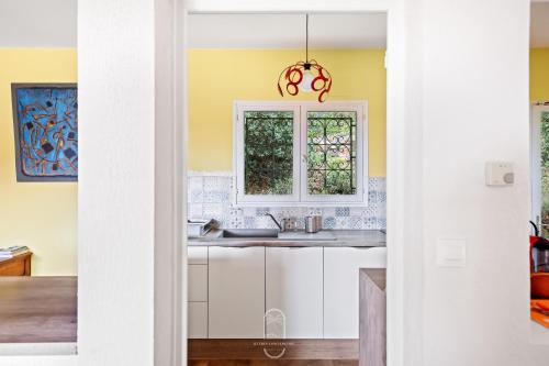 une cuisine avec un évier et une fenêtre dans l'établissement Villa les arbouses le Pradet, au Pradet