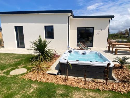 einen Whirlpool in einem Hof vor einem Haus in der Unterkunft Villa Palulova - maison 8 personnes - SPA in Plouescat