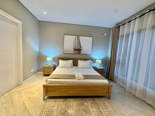 a bedroom with a bed and a sailboat on the wall at One Roma by the Cubes in Lusaka