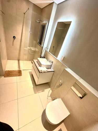 a bathroom with a toilet and a sink and a shower at One Roma by the Cubes in Lusaka
