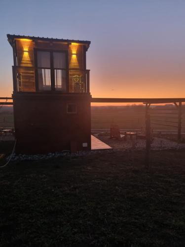a house with the sunset in the background at Natura Bungalow in Ždrelo