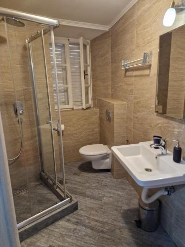 a bathroom with a shower and a sink and a toilet at Rooms Dana Old Town Budva in Budva