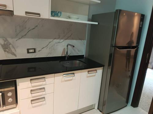 a kitchen with a sink and a refrigerator at Emerald Terrace Condo 3-Studio Garden Gem in Patong Beach