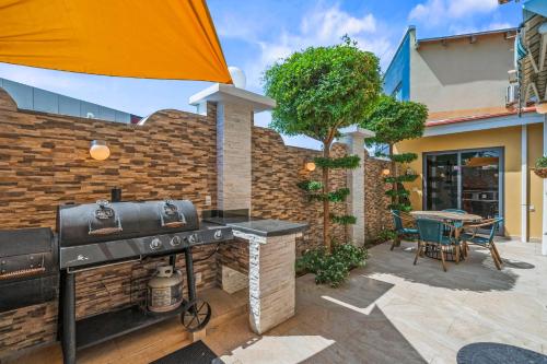a grill outside of a house with a patio at Palma Real 60 in Palm-Eagle Beach