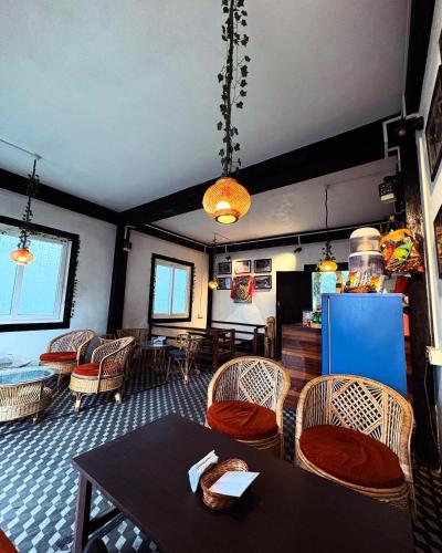 a dining room with chairs and a table and a refrigerator at The92dowhill farmhouse in Kurseong