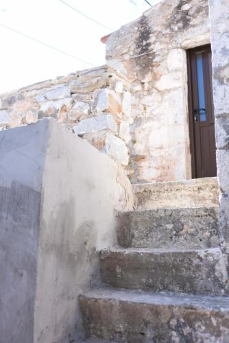 a stone building with stairs leading to a door at Basil Tree Stonehouse in Flomokhórion