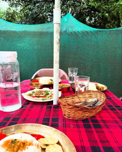 a table with a red table cloth with food on it at The92dowhill farmhouse in Kurseong