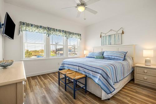 a bedroom with a bed and two windows at CR201 Salty Tides in Kill Devil Hills