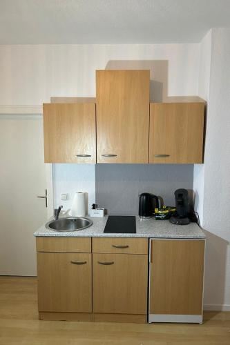 a kitchen with a sink and wooden cabinets at Am Kapellchen in Rüdesheim am Rhein
