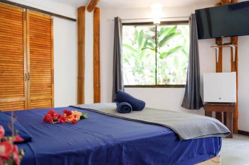 a bedroom with a blue bed with flowers on it at Bambutel Cocles in Puerto Viejo