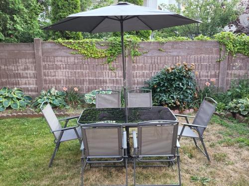 a table and chairs with an umbrella in a yard at Your home away from home in Pickering