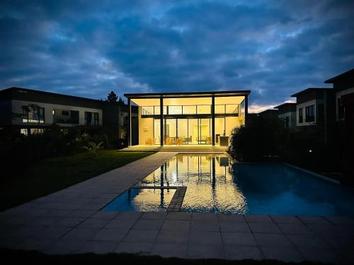a large glass house with a pool in front of it at One Roma by the Cubes in Lusaka