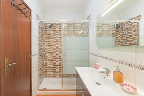 a bathroom with a shower and a sink and a mirror at Milfontes Beach House in Vila Nova de Milfontes