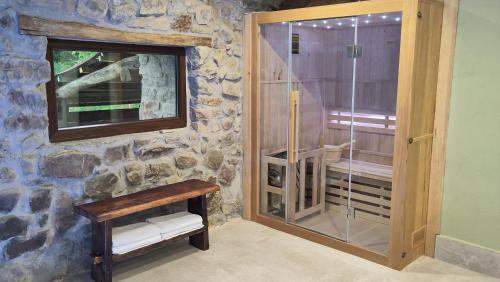 a stone bathroom with a shower and a glass door at Casa rural Abatetxe in Elgóibar